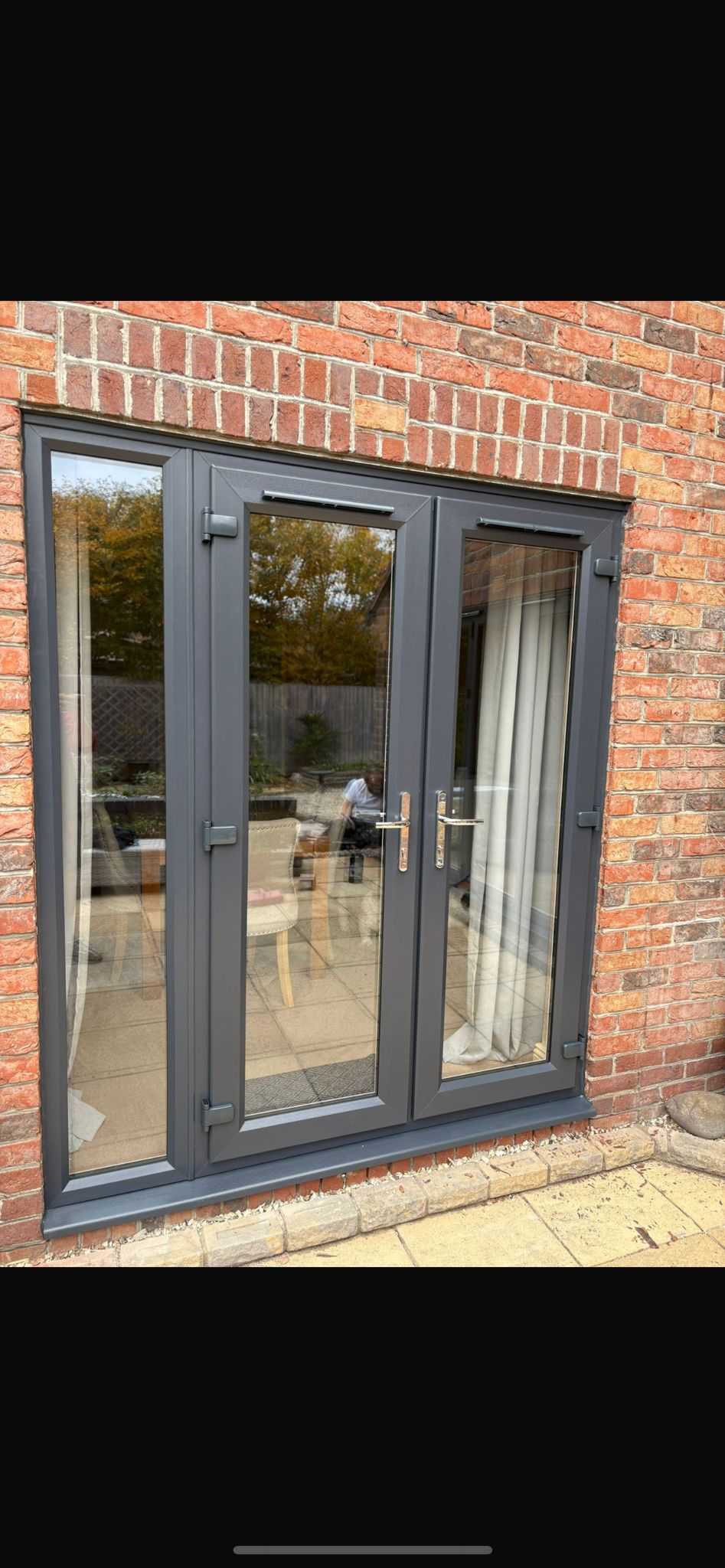 Modern grey bi-fold doors installation on brick extension in Oxfordshire